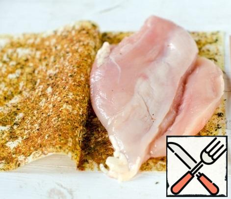For this recipe, we will need a seasoning for the tender fillet of chicken breast in Italian. Chop off the chicken breast and put it on a frying sheet, cover it carefully and press it down.