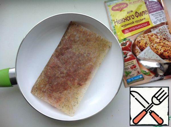 Heat a dry frying pan over the fire and put the wrapped chicken fillet on it. Cook on low heat for 7 minutes on each side.
