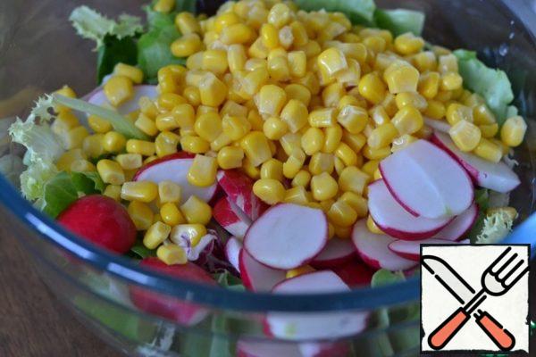 In a large bowl, spread the lettuce leaves.
Sliced radish, corn without liquid.