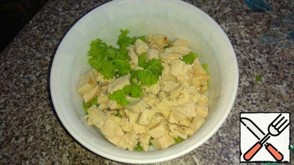 Cut the lettuce leaves, add the chopped chicken fillet.