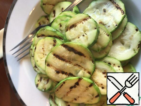 Peel the zucchini, cut into slices, add salt and fry in a frying pan on the grill.