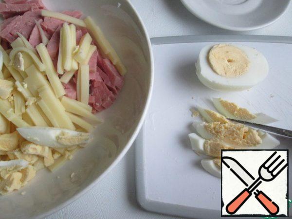 Cut the ham into cubes.
First cut the semi-hard cheese into plates, and then each plate into thin strips.
Cut the eggs in half lengthwise, and then cut into strips.
