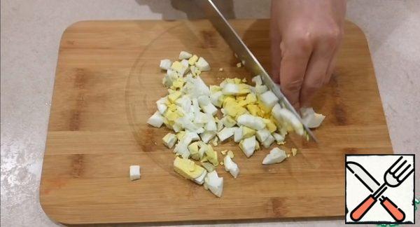 Boil the eggs. I cook them for 10 minutes, after the water boils. Cut the boiled eggs into cubes.