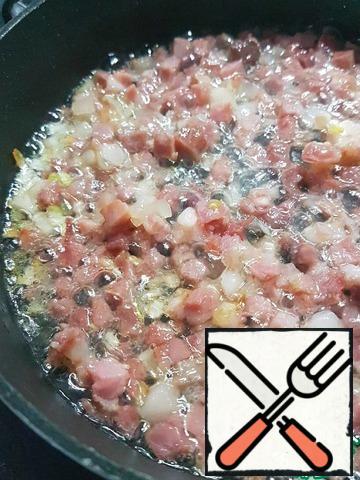 Finely chop the onion and fry it in a pan with the bacon.