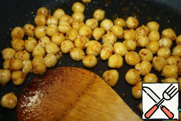 I always boil chickpeas in kilograms, and then freeze them in portions, so the cooking time is not taken into account.
Fry the chickpeas on a spoonful of oil with the addition of spices.
Season any - it's a good choice. I had a pinch of paprika, turmeric and hot pepper. Fry for about 5 minutes and let cool.