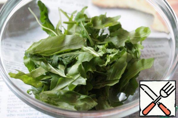 Wash the arugula, dry it, tear it and put it in a bowl.