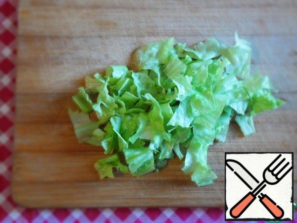 Wash the lettuce leaves in running water and dry them. Cut the thicker part ( at the base of the leaves), cut into medium pieces - the first cut.
The thin part is cut or cut with ribbons, set aside - the second cut.