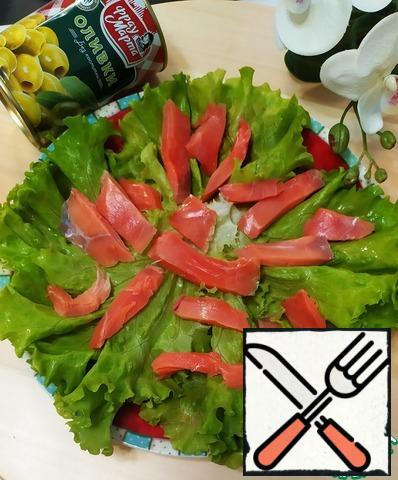 Next, prepare the salad. Put the salad leaves on the dish. Top with sliced fillet of lightly salted salmon.