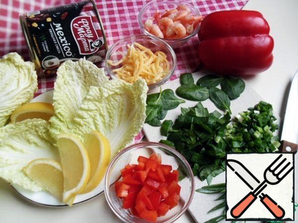 We will prepare the necessary products. The amount of food depends on the size of the cabbage leaves (and your appetite).
I had leaves the size of a small palm. Wash and dry the vegetables.
Open a jar of vegetable mixture.
The mix "Mexico" includes red beans, corn, sweet pepper and tomato paste, the taste is balanced and independent. But since the salad is being prepared, add some fresh vegetables and prawns, which need to be boiled, cleaned, and cooled. If you have prawns already boiled and frozen - just put them in boiling water for 3-4 minutes.
Grate the cheese or cut it into thin strips.
Sweet pepper-diced.
Lemon slices.
Spinach-strips, green onions finely chop (leave some greens for the salad decor)