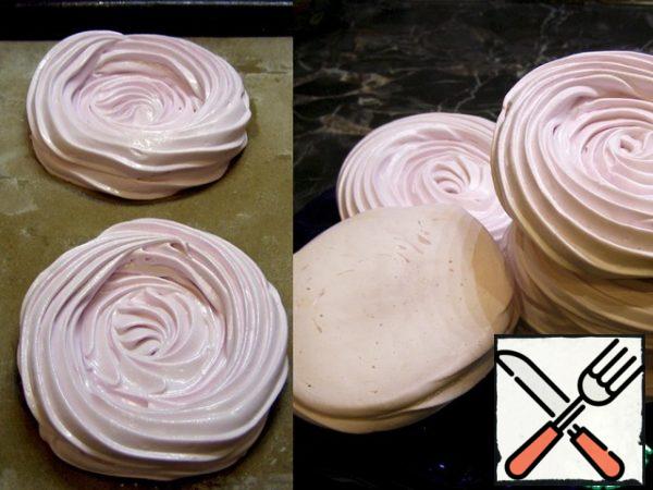 Using a pastry bag with a nozzle (or just a spoon), we put the meringue on a sheet, forming a side 1.5 – 2 cm high. Pre-close the sheet with baking paper. I made a portion dessert, I got 6 pieces with a diameter of 9 – 10 cm. Put the meringues in a preheated oven and bake at T=100*C.
There is an important point: the temperature should not be higher, otherwise the meringues will darken (fry), crack or dry out. If your oven has the lowest possible temperature above 100*C, you will have to bake with the oven slightly open. I kept mine half open.
It is also important not to overdo the meringue: it should have a hard crust on the outside, but remain creamy inside. Readiness can be checked with a wooden stick. Mine were baked for 55 minutes. Ready-made meringues are left in the oven until completely cool, at least for 2-3 hours.
Meringue can be baked in advance.