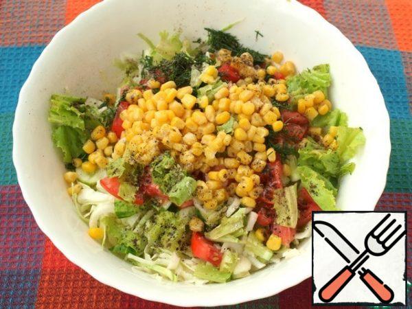 Add the chopped dill to the bowl, tear the lettuce leaves and add the canned corn. Add salt and pepper to the salad.