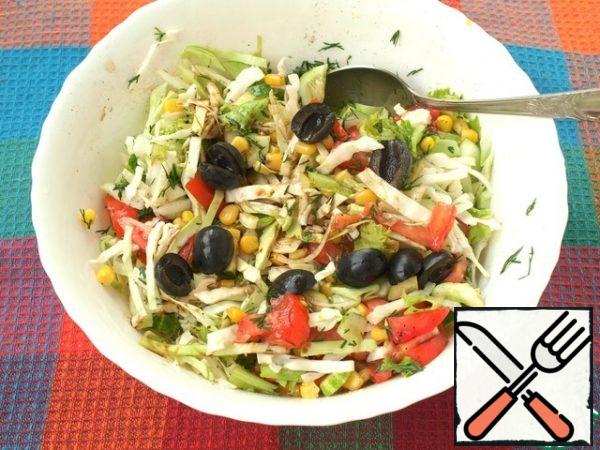 Cut the olives in half and add to the salad.