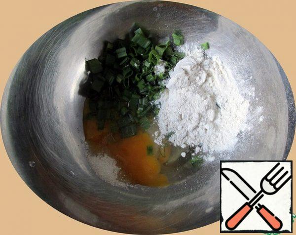In a bowl, break the eggs, add salt, sugar, herbs of Italian cuisine, chopped green onions and flour.