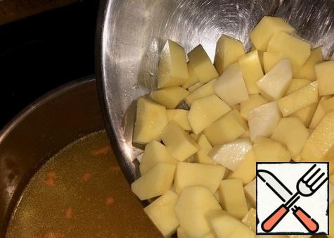 Broth, let me remind you, carefully strained, bring to a boil and send it five pieces of not very large potatoes. Potatoes should not be cut very small, but not large. In General, so that the spoon is well laid down and it was convenient to eat.