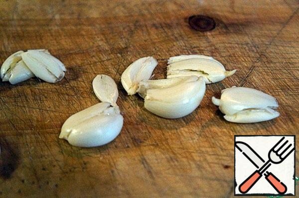 Crush the garlic with a knife.