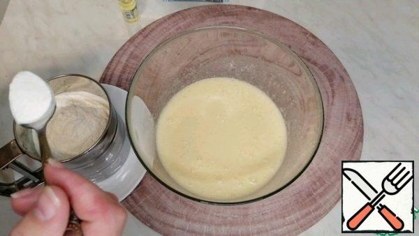 Then take the flour, add baking powder for the dough.