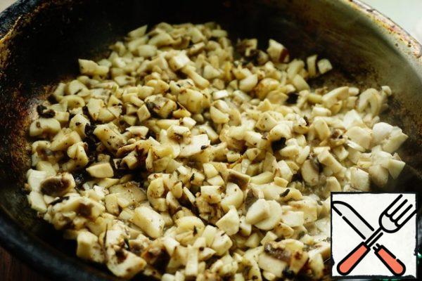 Pour vegetable oil into a preheated pan. We send not her mushrooms. As soon as the mushrooms begin to secrete juice, add crumbled dry porcini mushrooms to them.