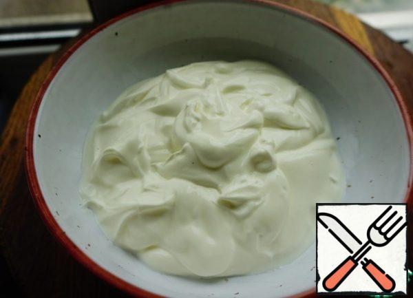 Start preparing the filling. Spread the sour cream.