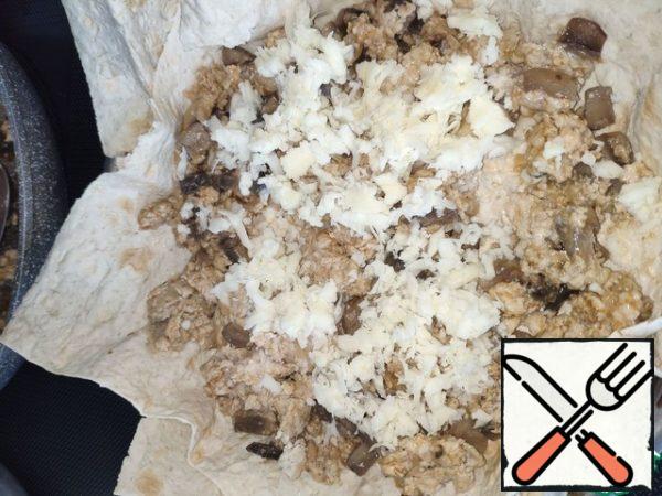 Put a sheet of pita bread in a mold greased with vegetable or butter. Put the filling on top and sprinkle with cheese. So three or four times.