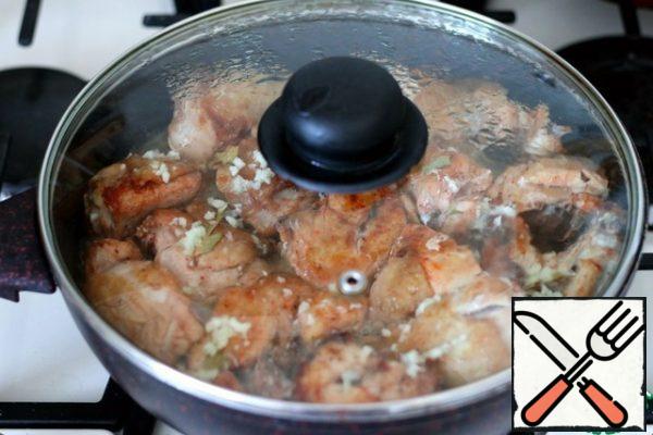 As soon as the chicken is fried, pour over the chicken pieces with the prepared garlic solution and immediately cover the pan with a lid. Bring the chicken to readiness. This usually takes 10-15 minutes.