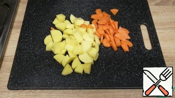 Cut the potatoes into cubes, and the carrots into half-rings.