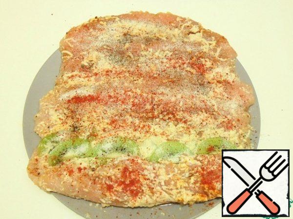 Place kiwi slices sprinkled with spices and crushed gelatin along the edge of the flattened fillet.
