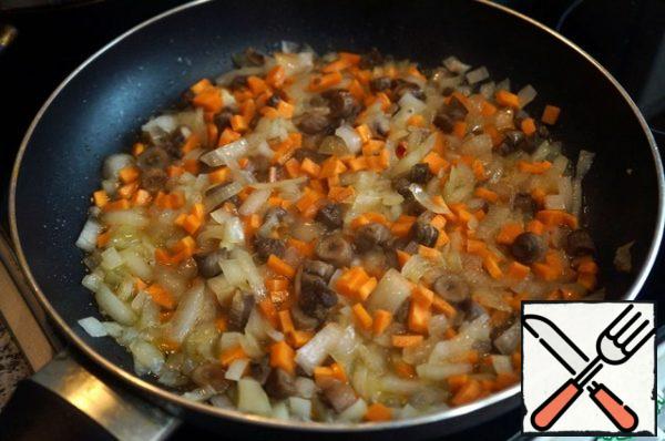 In a frying pan, heat two-thirds of the melted butter. Passer the onion until transparent. Add the carrots and mushrooms, stir, and fry for 5 minutes over medium heat. Add a ladle of broth from the pan, cover the pan with a lid and simmer the vegetables and mushrooms over low heat for 15 minutes.