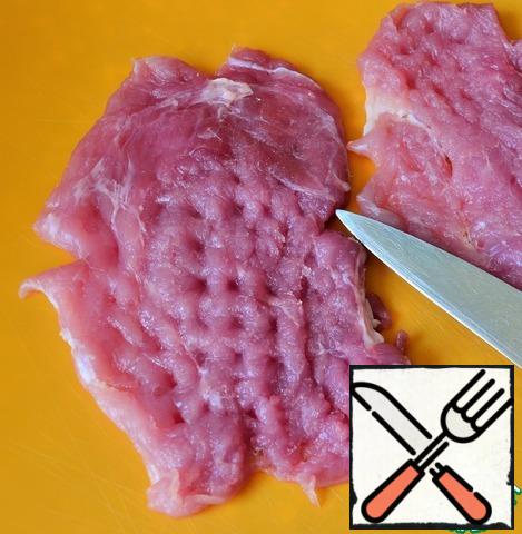 Make four incisions along the perimeter with a knife,
this will prevent the chops from twisting when frying.