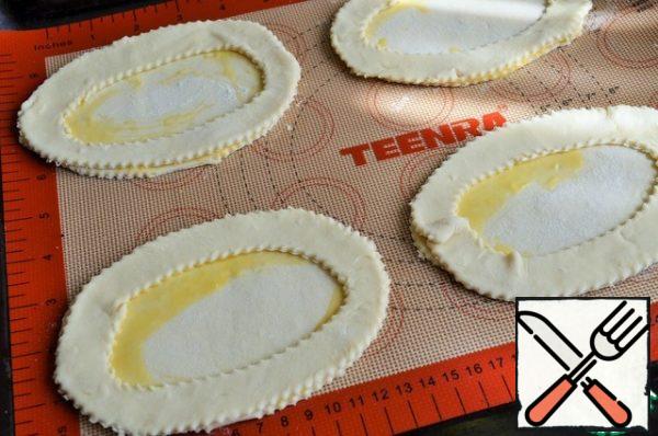 Beat the egg, lubricate the edges of the bottoms, spread out the sides.