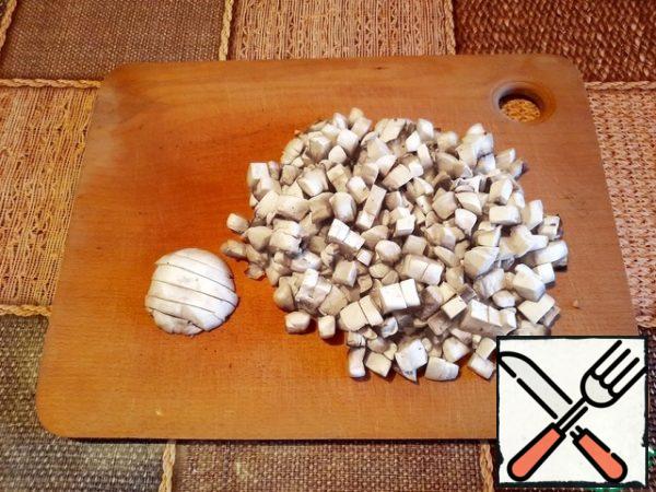 Peel the mushrooms and fry until soft. I always wash mushrooms, remove the top skin from the cap. Then they should be cut and fried until all the water evaporates.