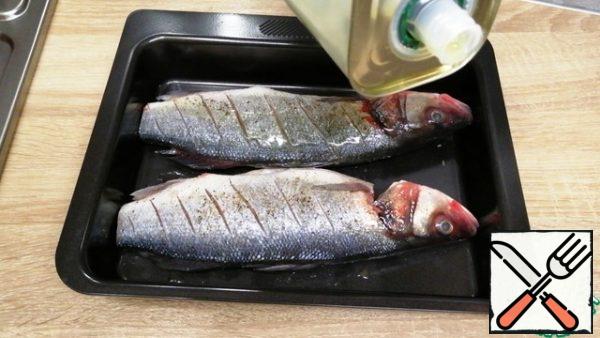 Put the fish in a deep pan, season with salt and pepper and pour olive oil on both sides. RUB it with your hands. If it doesn't fit completely, you can trim the tails.