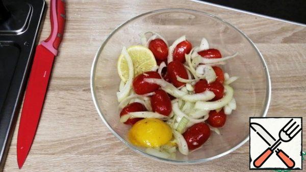 Cut the onion into half rings, garlic straws, 1/3 lemon slices, put everything in a deep bowl, add cherry tomatoes, half a teaspoon of salt, 2 tablespoons of olive oil, chop black pepper. Mix well so that everything is covered with oil.