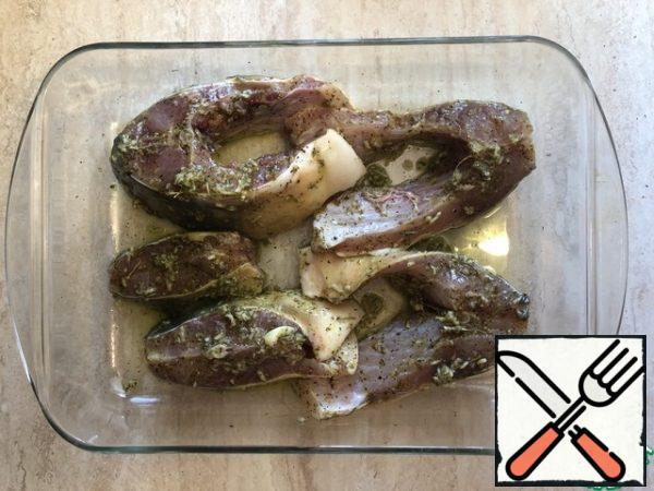The resulting garlic mixture to RUB the pieces of carp. Leave to marinate for 10-15 minutes.
To turn on the oven and set to 200.