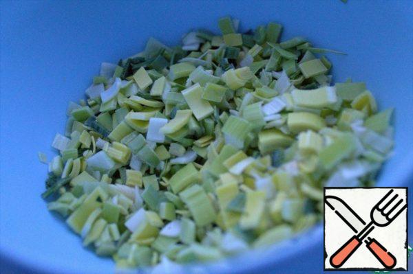 Cut the green onions. I have leeks. It is convenient to cut lengthwise in advance and wash the stem, then cut it into small pieces and put it in a box with a lid in the refrigerator. Then we take it out and add it to salads or pies.