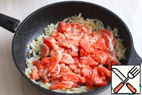 Cut the salmon (300 gr.) into thin strips/pieces, add the fish pieces to the pan with the sauteed onion. Put the pan on a medium heat and lightly simmer the fish for about 3-5 minutes. Until ready, the fish will reach when baking the pie.