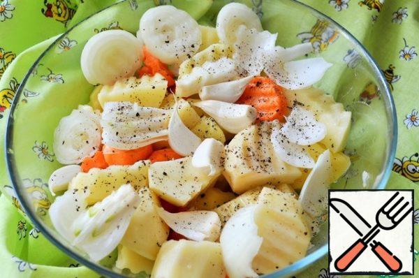 Wash the potatoes and carrots, peel the onion and cut it into convenient slices.
Parse the garlic into cloves.
Add salt, pepper and pour in 1 tbsp vegetable oil, mix.