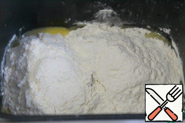 Pour the warm oil solution into the yeast and add the sifted flour.
Set the program "Dough", designed for 1 hour and 30 minutes, and turn on the bread maker.