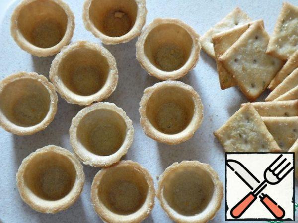 Prepare the tartlets. I was counting on the filling for large tartlets, but I have a mini now, so I took a cracker, you can also use slices of bread, pre-sliced and dried in the oven, toaster or in a dry frying pan.