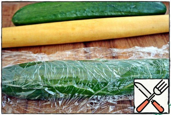 For the last time, after bathing the unsuspecting cucumbers under running water, carefully wiped them with a towel, laid them on the Board, gently covered them with cling film, and began to beat them... How to do this is a personal matter, since I do not like a kitchen hammer and consider it a terribly traumatic tool, I chose a rolling pin...