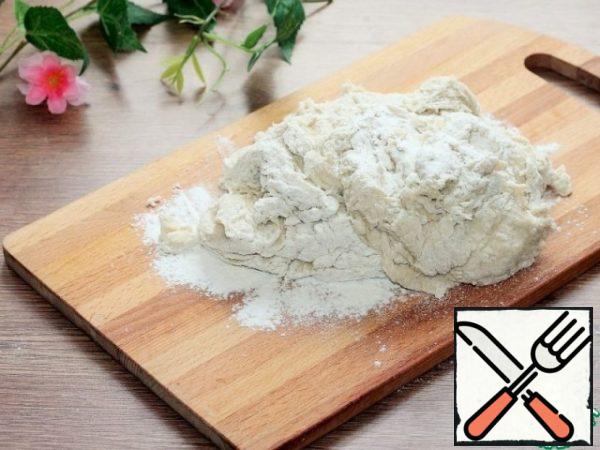 Pour the last two spoonfuls of flour onto a cutting board and knead a smooth, shiny dough that does not stick to your hands.