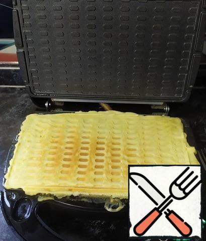 Open the lid of the multi-Baker. Transfer the browned waffle to the Board.