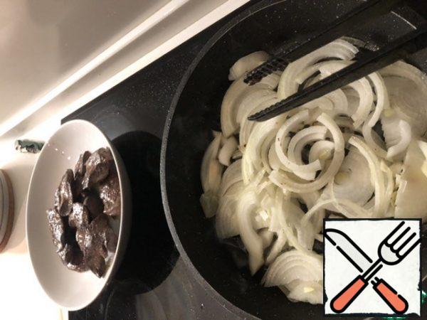 Cut the onion into half rings, put it in the same frying pan and fry in the same oil in which the liver was fried. If there is not enough oil, then add a little more. Fry the onion for 5-6 minutes, until soft. Add balsamic cream.