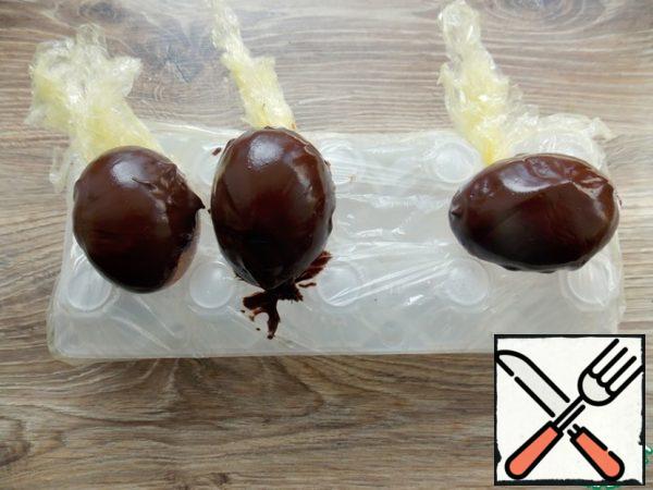 Melt the chocolate in a water bath to its current state. Dip the egg halves and turn them over. Lay out the chocolate and wait until it hardens properly. As a stand, I took an egg cell, washed it with soap and loosely covered it with a film.