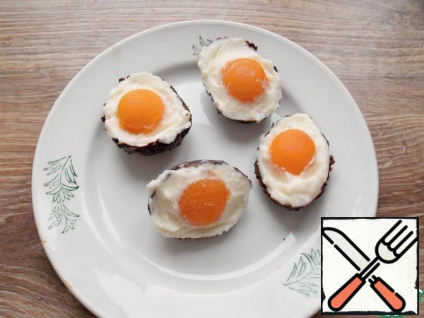 Fill the chocolate shells with a creamy mass and immediately pour the apricot yolk. Put in the freezer for 10-15 minutes, then transfer to the refrigerator. It is advisable to fill them no more than 3-4 hours before serving.