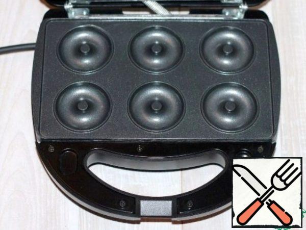 Open the lid of the slow cooker and install the panel for donuts.
