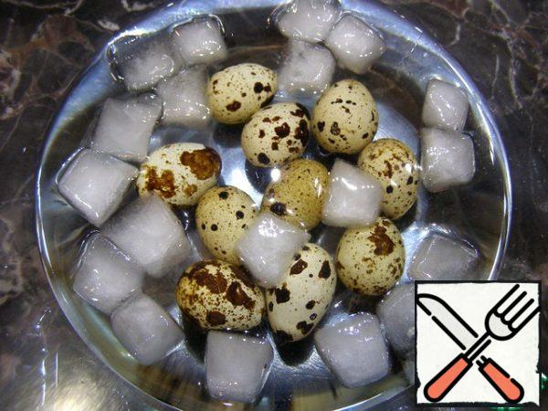 The cooked eggs are immediately lowered into very cold water, where they are left to cool.
