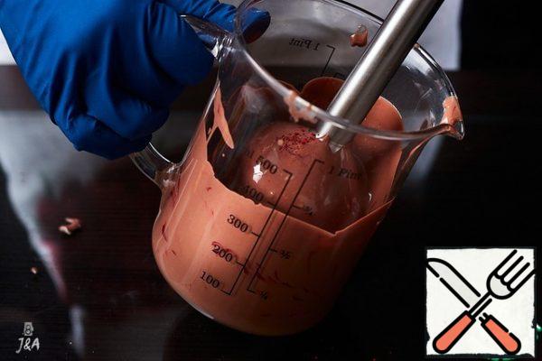 Pour the melted chocolate into a glass. Pour in a food-grade fat-soluble dye. One pinch is enough. Whisk with a blender with a knife attachment.
