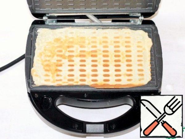Baked waffles, without cooling, quickly roll into a tube.