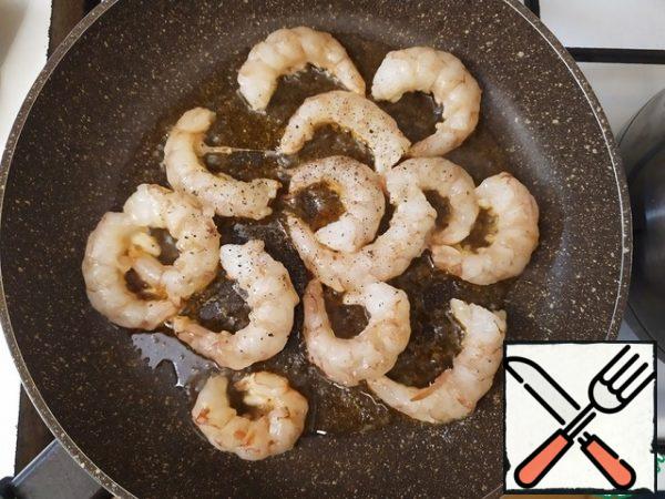 Add the olive oil and prawns to the preheated pan. Salt, pepper and fry them (1-2 minutes on each side).