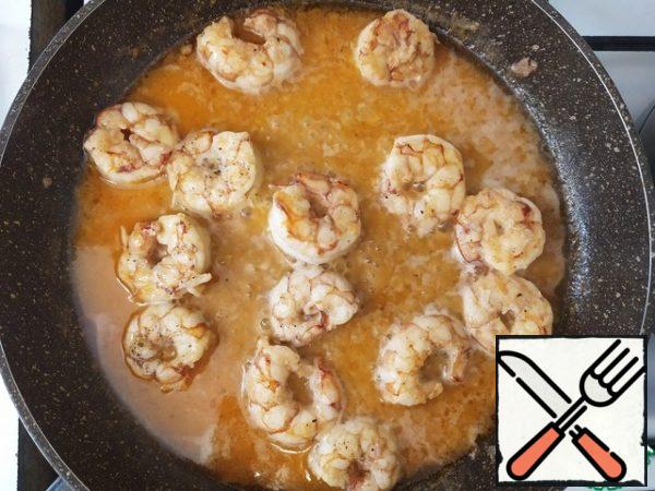 Add the wine, lemon juice from one lemon and the zest from it. Cook until the prawns are reduced by half or, in other words, until ready. Be careful not to overdo the shrimp, so that they do not become rubber.